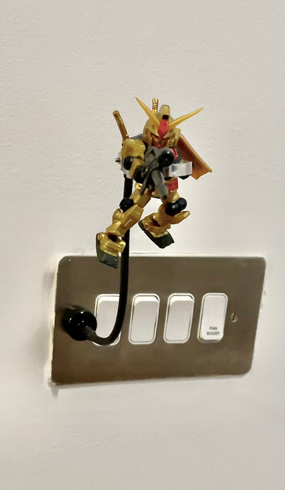 Mobile Suit Ensemble gundam on a magnetic stand attached to a power switch panel